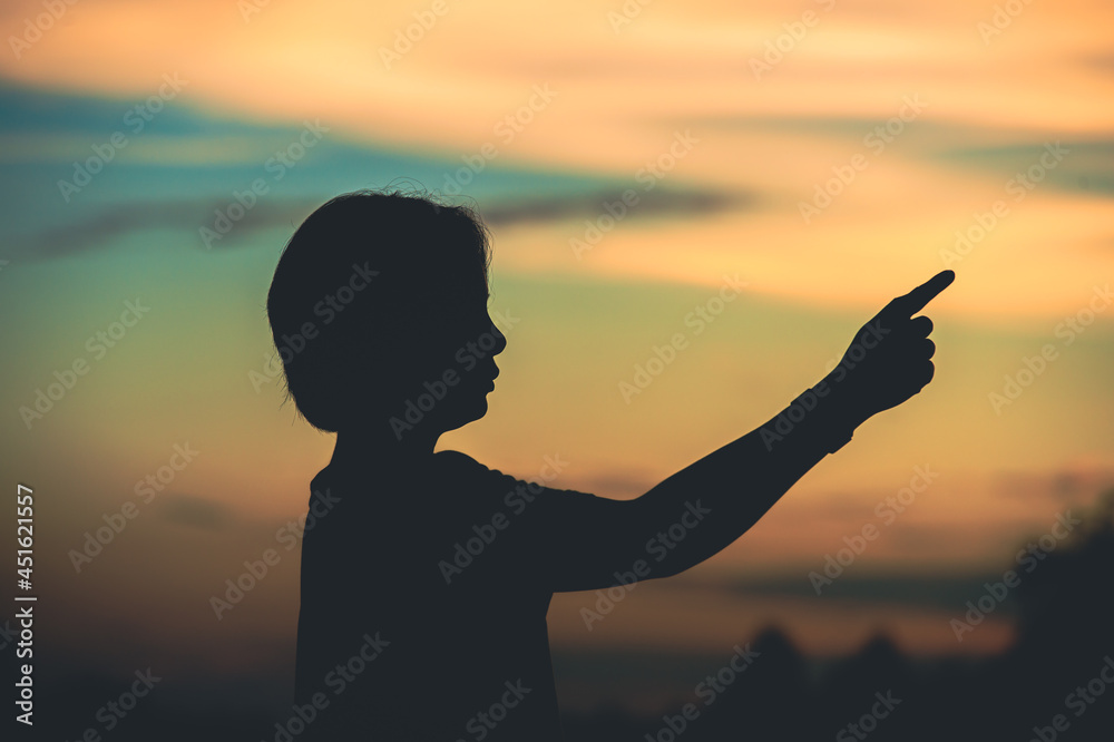 Fototapeta premium young woman pointing her hand aiming destination success at sunset.