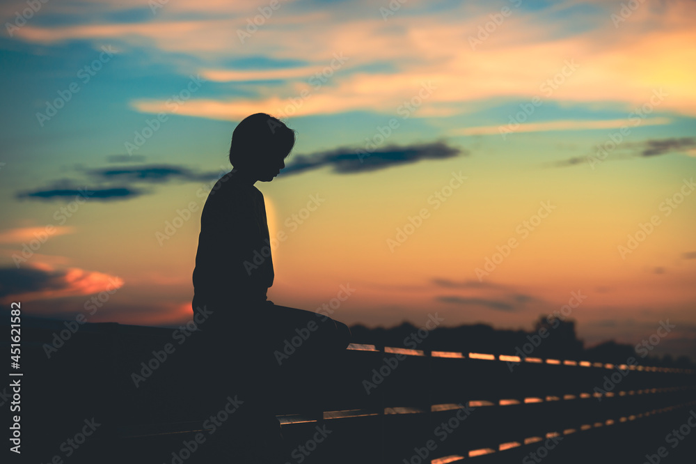 silhouette woman with sadness at sunset alone. silhouette woman with sadness at sunset alone.