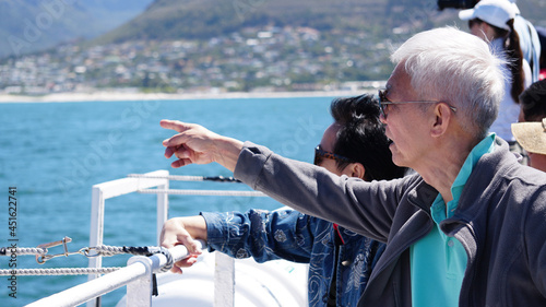 Asian senior elderly couple on tourist ferry boat to seals island trip attracion Fun wildlife watching aticity in South Africa trip photo