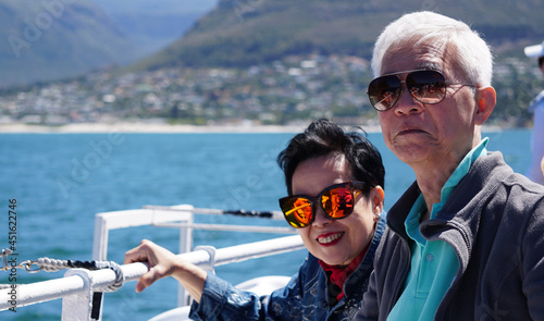 Asian senior elderly couple on tourist ferry boat to seals island trip attracion Fun wildlife watching aticity in South Africa trip photo