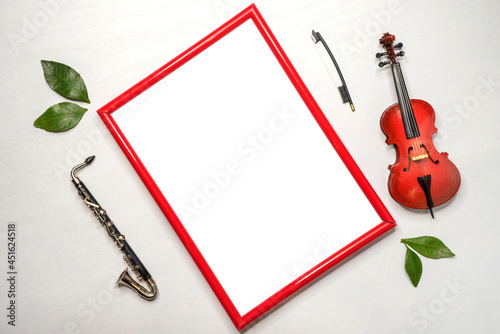 Tablet with a red frame to insert an image of a violin, and a saxophone