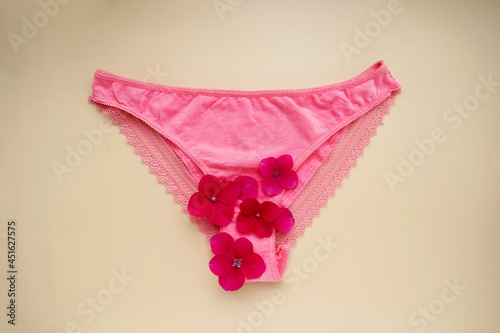 Woman's health concept. Pink panties with red flower. Abstract mentruation, period. photo