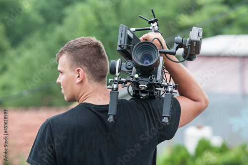 Behind the scene. Cameraman with his camera on outdoor set