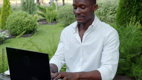 African-American businessman, works at a laptop in a cafe, freelancer