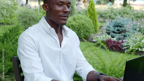 African-American businessman, works at a laptop in a cafe, freelancer