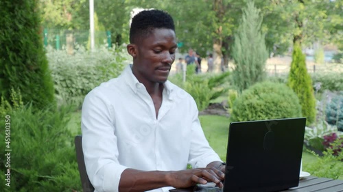 African-American businessman, works at a laptop in a cafe, freelancer