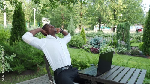 African-American businessman, works at a laptop in a cafe, freelancer