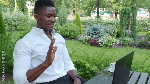 African-American businessman, works at a laptop in a cafe, freelancer