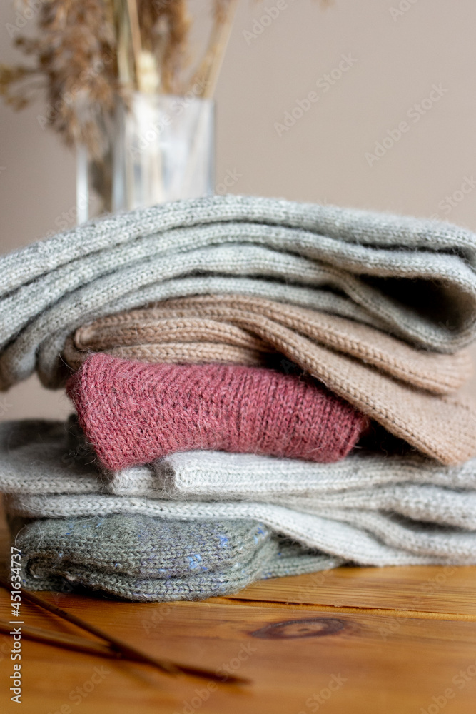Pile of woolen knitted socks on wooden table Pile of woolen knitted socks on wooden table