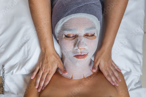 Фотография Woman with her face covered with gauze for skin treatment receiving shoulders ma