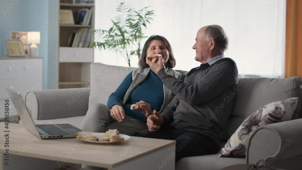 elderly loving couples enjoy joint relaxation and feed each other with sandwiches elderly loving couples enjoy joint relaxation and feed each other with sandwiches