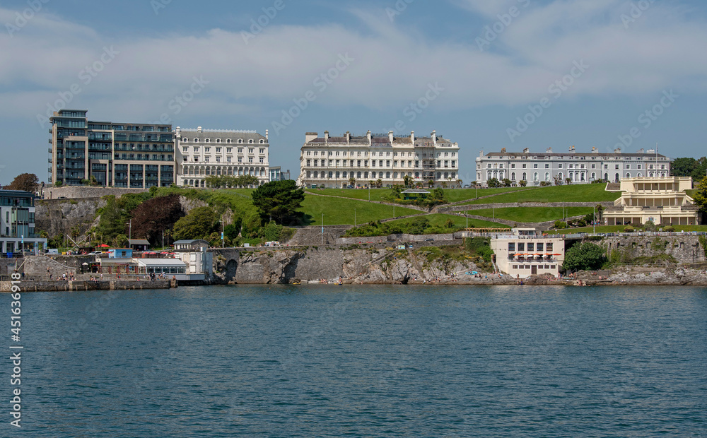 Plymouth, Devon, England, UK. 2021. View of the Plymouth waterfront properties seen from Plymouth Sound viewing Plymouth Hoe, and overlooking buildings.
