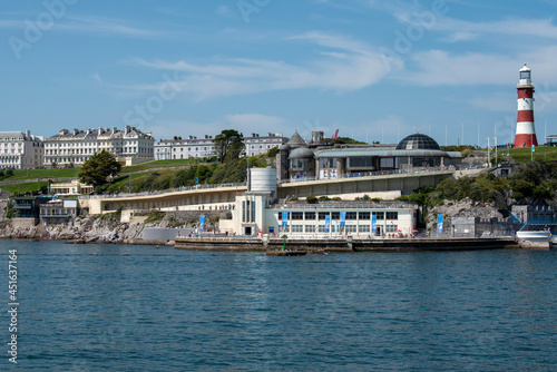 Fototapeta Naklejka Na Ścianę i Meble -  Plymouth, Devon, England, UK. 2021. View of the Plymouth waterfront properties seen from Plymouth Sound viewing Plymouth Hoe, Smeatons Tower and Tinside Lido, leisure area.