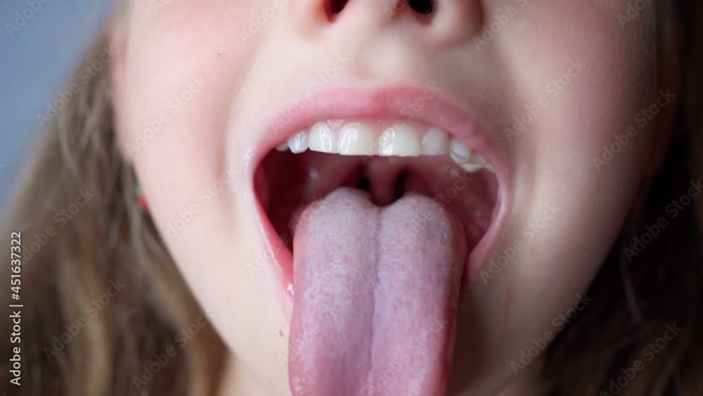 girl opens her mouth wide and pulls out long tongue. child ...     