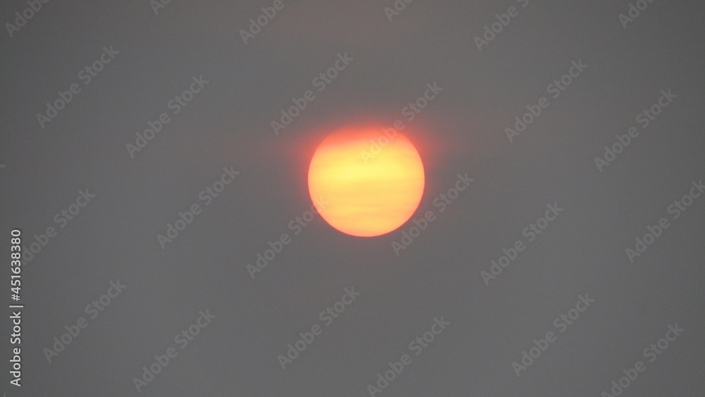 The orange sun in the smoke of forest fires in Yakutia can be viewed with an unarmed eye