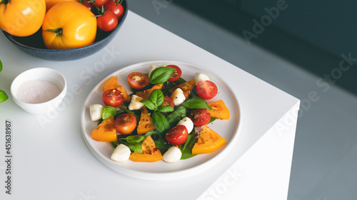 Italian caprese salad with tomatoes, mozzarella cheese and basil in plate