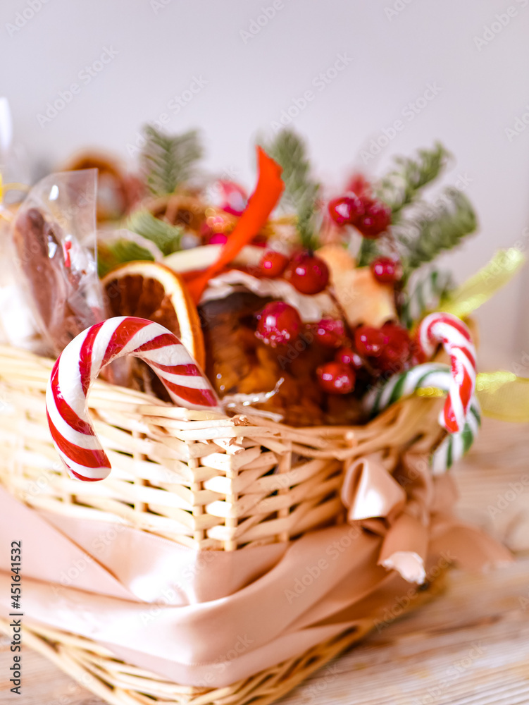 Christmas edible gift basket,  Food Christmas gift made of cookies, honey, homemade handmade sweets, dried oranges, lollipops on a wooden table.Concept handmade christmas gifts, Handmade food presents