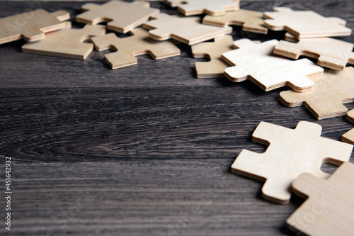 puzzle elements on a wooden background as a riddle photo