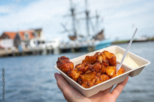 Portion of popular dutch street snack food called kibbeling, which consists of fried cod fish and a sauce photo