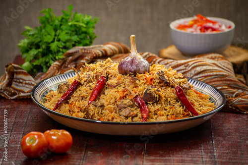 Tableau sur toile Delicious Fergana pilaf. Uzbek favorite dish on wooden background