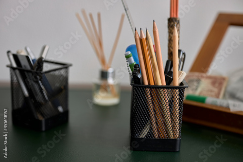 A basket of pencils and pens on an office table