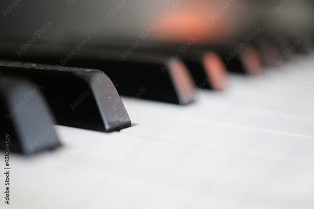 Piano keys with orange reflection