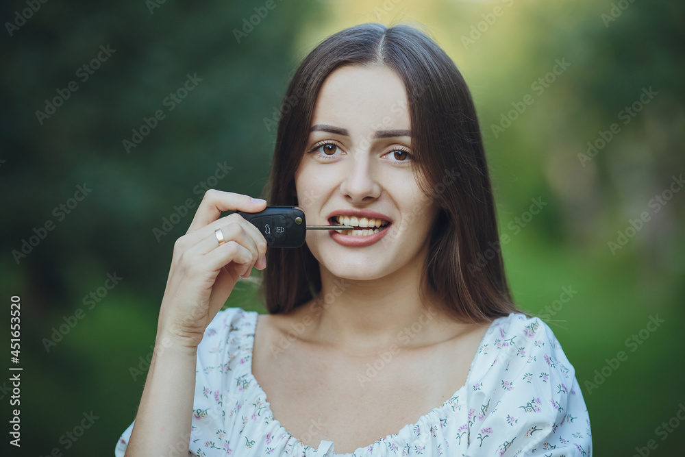 Young beautiful girl holding car keys in hand
Young beautiful girl holding car keys in hand