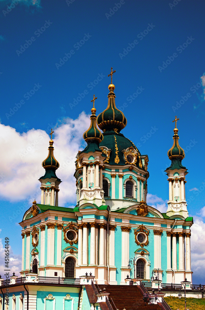 Picturesque landscape view of ancient Saint Andrew's Church against blue sky with white clouds at sunny day. Designed by architect Bartolomeo Rastrelli in Baroque style. Sacred christian building