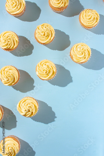 Vanilla cupcakes with yellow frosting on a blue background