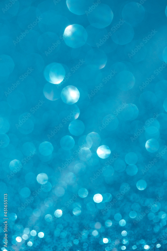 Blue sparkle glitter background. Holiday abstract defocused background.