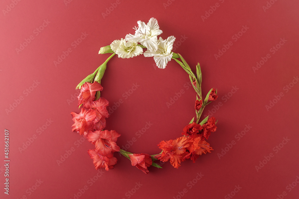Wreath of autumn flowers on a dark red background. Floral composition.