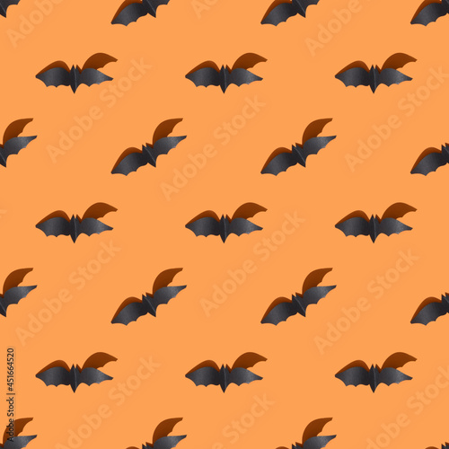 Seamless Halloween pattern of black bat on orange background.