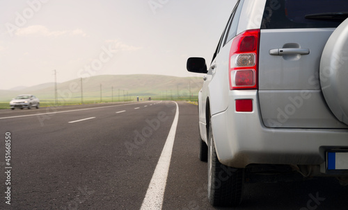 Dusty car on asphalt straight road