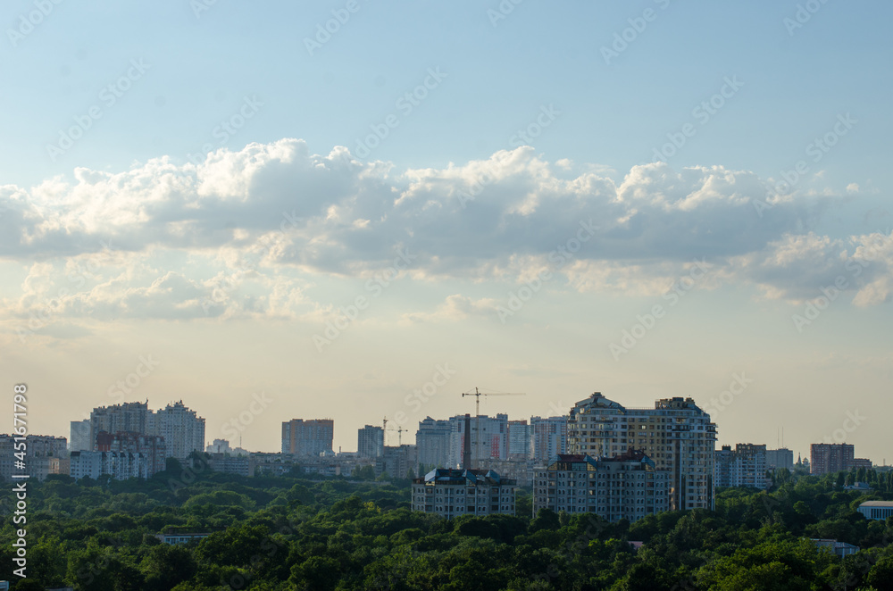 Odessa, Ukraine evening city view landscape with trees, buildings, construction cranes and cloudy sky