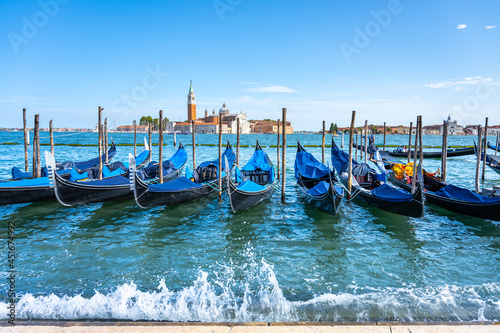 Moored gondolas at St. Mark Square with Church of San Giorgio Maggiore on background. Venice, Italy photo