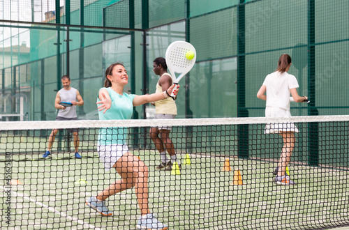 Sporty woman and other athletes training on the tennis court © JackF