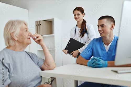 an elderly woman in a medical office a nurse and a doctor providing hospital services