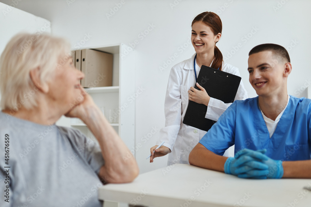 an elderly woman communicates in a hospital with a doctor and a nurse assistant an elderly woman communicates in a hospital with a doctor and a nurse assistant