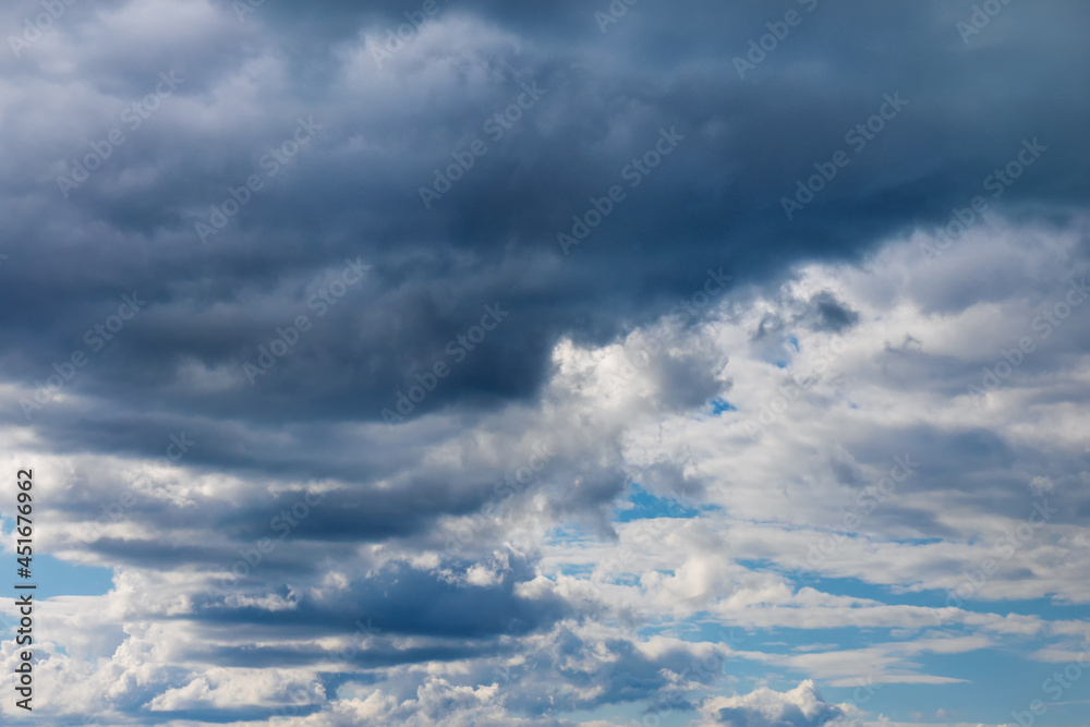 Light and dark clouds on blue sky. Colorful cloudscape background.