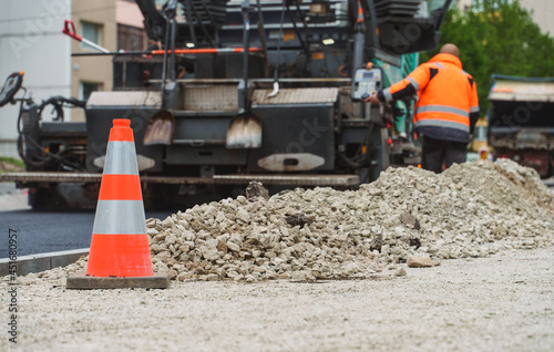 Road paving machine stacking asphalt on the street.