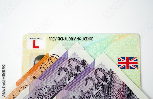 UK Provisional Driving Licence card and British pound notes. Document for learner driver.  Genuine document. Concept. photo