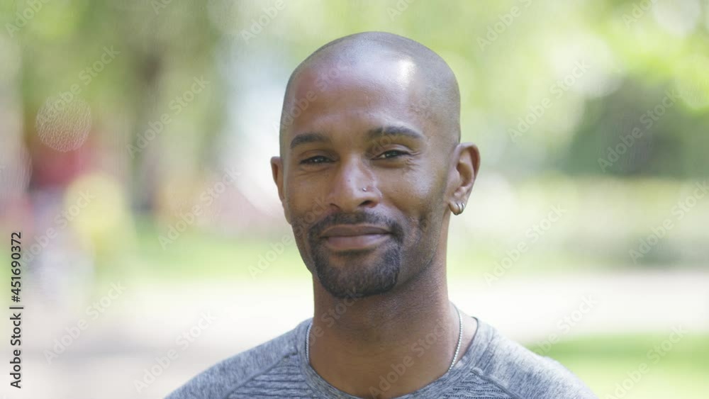 Portrait of handsome black male turning to camera and smiling, in slow motion Portrait of handsome black male turning to camera and smiling, in slow motion