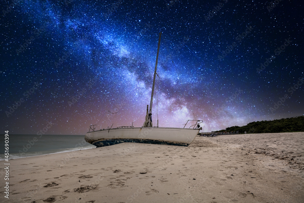 Milky way in the night sky over a shipwreck off the coast of Clam Pass - obrazy, fototapety, plakaty 