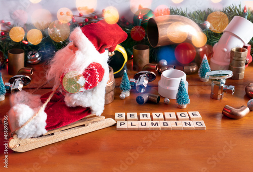  Christmas composition decoration with Santa Claus riding on sleigh and plumbing tools.