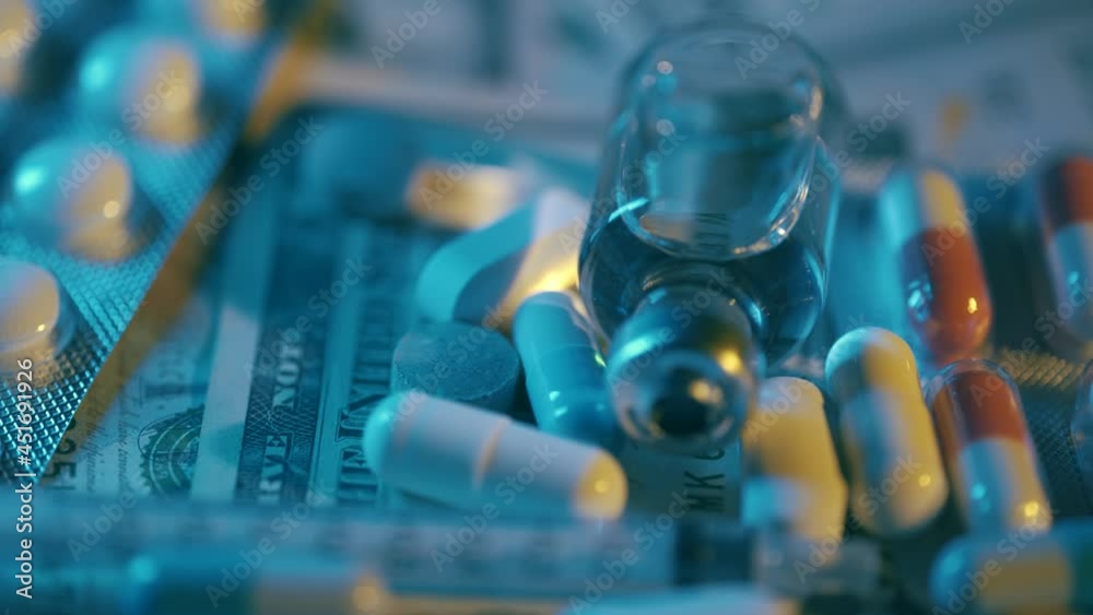 Close up view of medical pills rotating on the dollar banknotes. Rising cost of healthcare. Coronavirus outbreak. Concept of pharmacy and medicine or treatment cost and illness or flu. Close up. Close up view of medical pills rotating on the dollar banknotes. Rising cost of healthcare. Coronavirus outbreak. Concept of pharmacy and medicine or treatment cost and illness or flu. Close up.