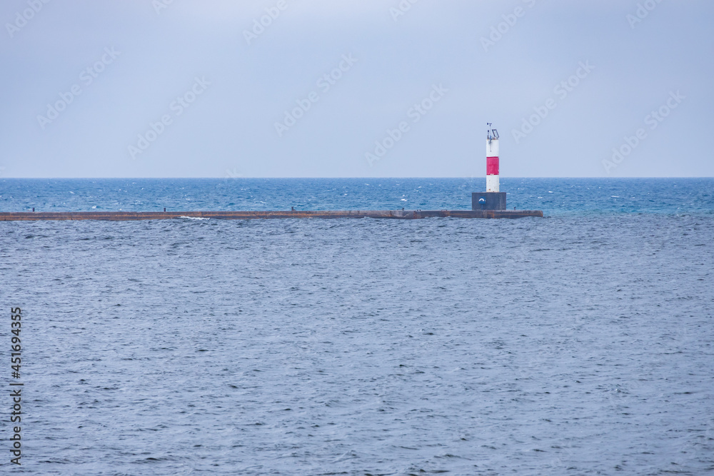 White and red beacon on breakwater in Lake Michigan