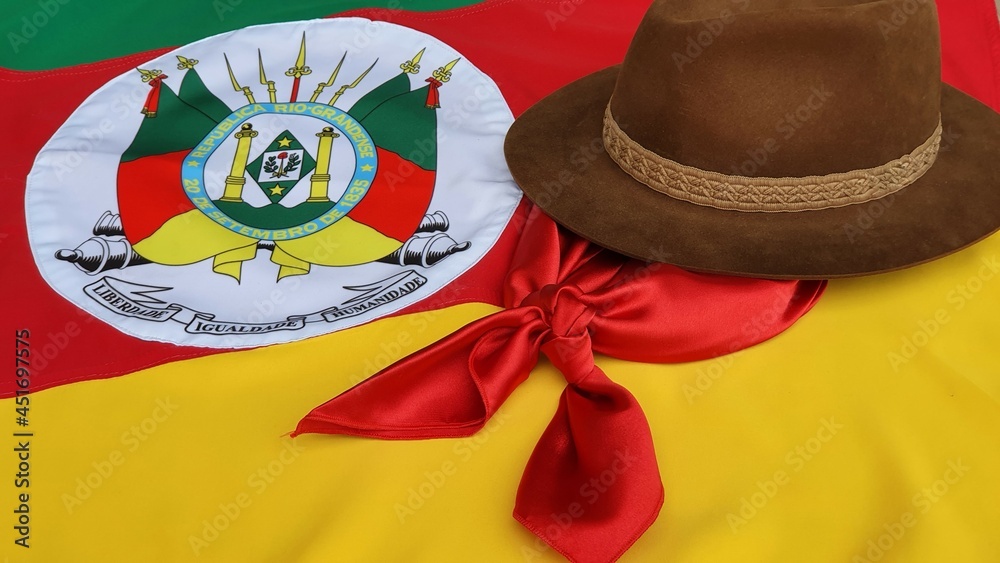 Hat, red gaucho scarf and State Flag of Rio Grande do Sul - Brazil, on the  table. Decoration to commemorate the traditional Week in southern Brazil.  Farroupilha from the Gauchos. Photos
