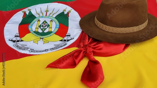 Hat, red gaucho scarf and State Flag of Rio Grande do Sul - Brazil, on the table. Decoration to commemorate the traditional Week in southern Brazil. Farroupilha from the Gauchos. photo
