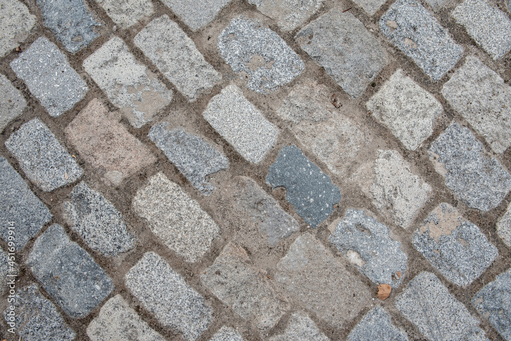 cobblestones of a street paving on the diagonal of the frame. Vector granite texture background cobblestones of a street paving on the diagonal of the frame. Vector granite texture background