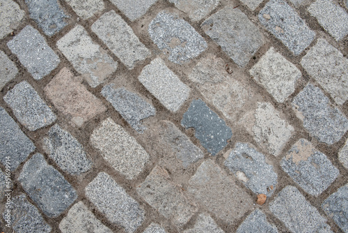 cobblestones of a street paving on the diagonal of the frame. Vector granite texture background